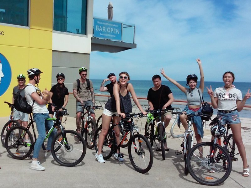 bike tour group posing near sea on bicycles