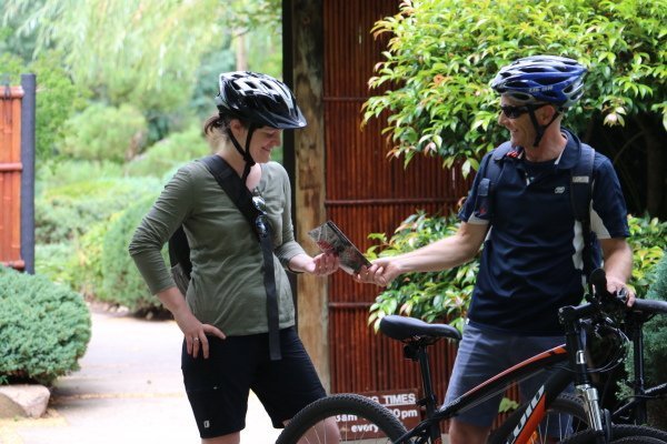 cyclists reviewing map near river torrens linear trail